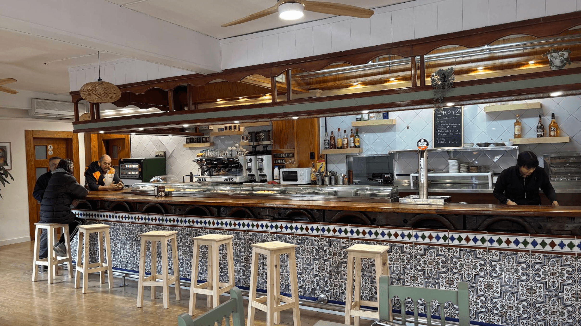 Barra y sala del restaurante con taburetes y azulejos tradicionales